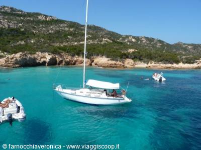 Sailboat anchored in cove with turquoise water and granite rocks
