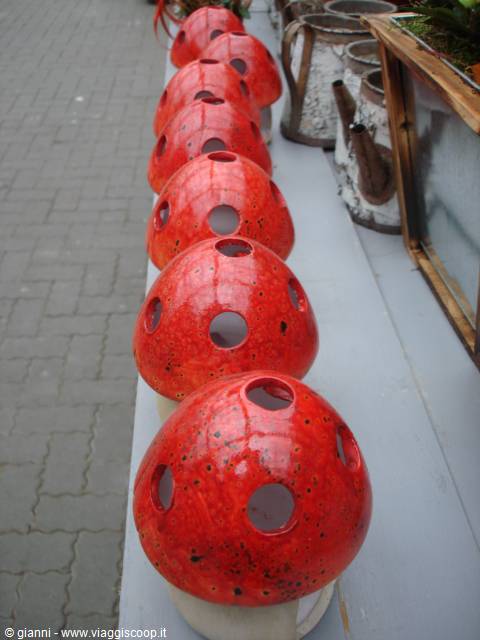Red ceramic mushroom lamps lined up on an outdoor stall