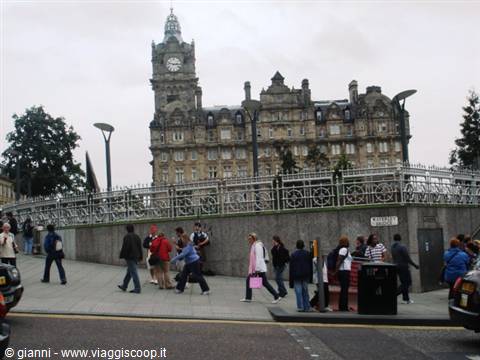 Tourists walking past the Balmoral Hotel in Edinburgh under a grey sky