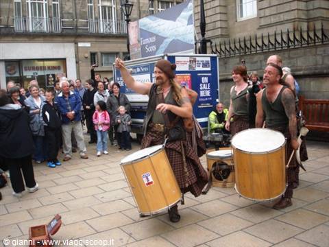 Street drummers in kilts perform with big drums for the crowd, Edinburgh