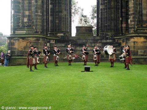 Pipe band in kilts playing on the lawn beneath the Scott Monument, Edinburgh