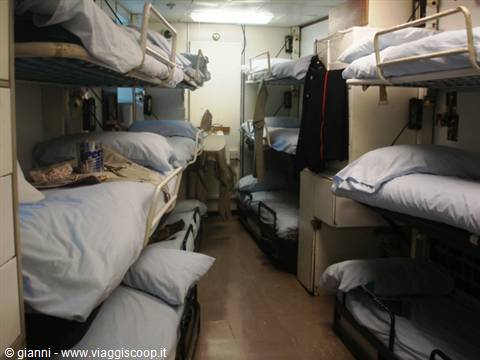 Bunk beds cabin with blue sheets under artificial light