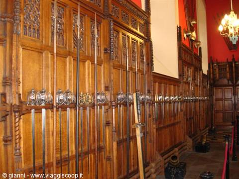 Antique swords and weapons hanging on oak panels in Edinburgh Castle's Great Hall