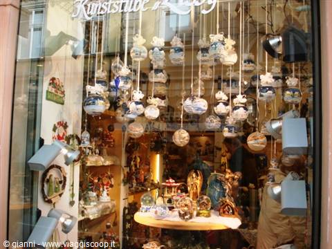 Shop window with hanging painted ceramic ornaments, warm interior lighting