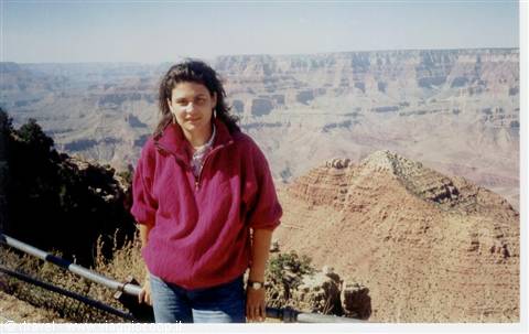 Girl in red fleece standing by the railing at the Grand Canyon