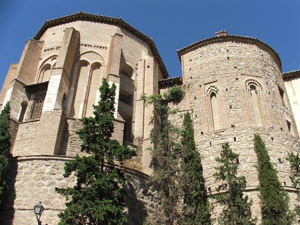 Mudéjar stone and brick apses in Toledo, cypresses against a blue sky
