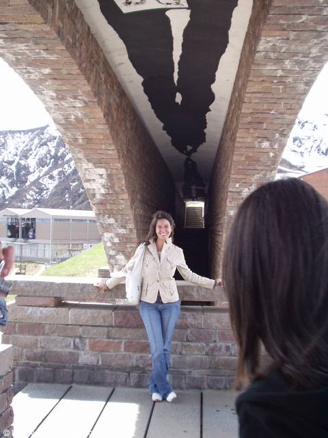 Smiling woman under the great brick arch of San Giovanni Battista church in Mogno