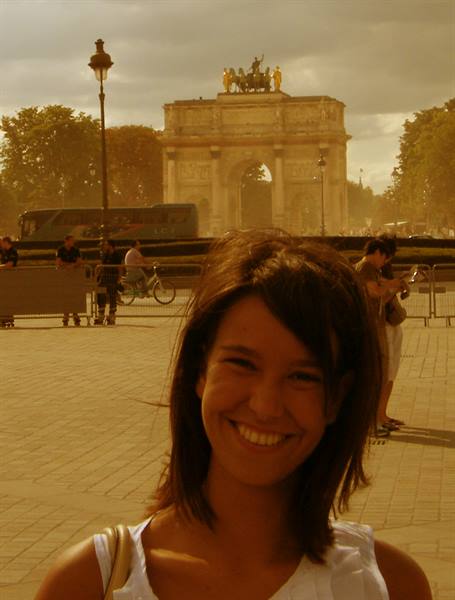 Smiling girl in front of the Arc de Triomphe du Carrousel in Paris