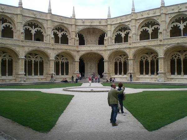 Manueline cloister of the Jerónimos Monastery in Lisbon, visitors walking