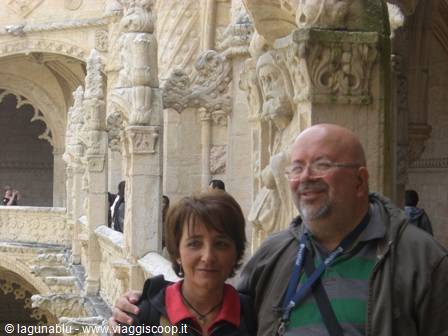 Smiling couple in front of the Manueline cloister of Jerónimos Monastery, Lisbon