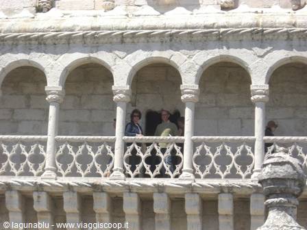 Tourists beneath the limestone loggia arches of Belém Tower, Lisbon