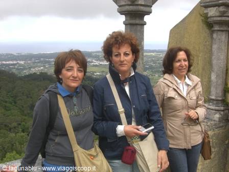 Three tourists near stone columns on the Pena Palace terrace, Sintra