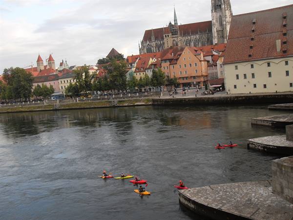 Kayakers on the Danube in front of Regensburg Cathedral and colorful houses