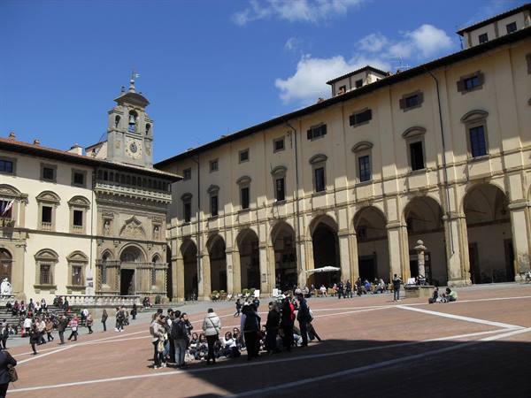 Tourists in Arezzo's Piazza Grande in front of the Vasari Loggia