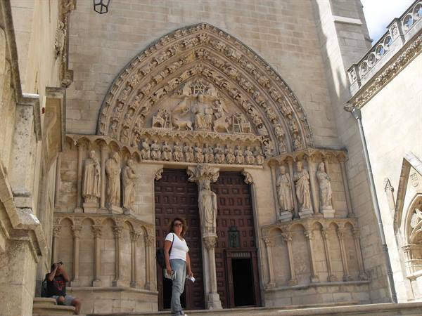 Woman in front of the carved Gothic portal of Burgos Cathedral