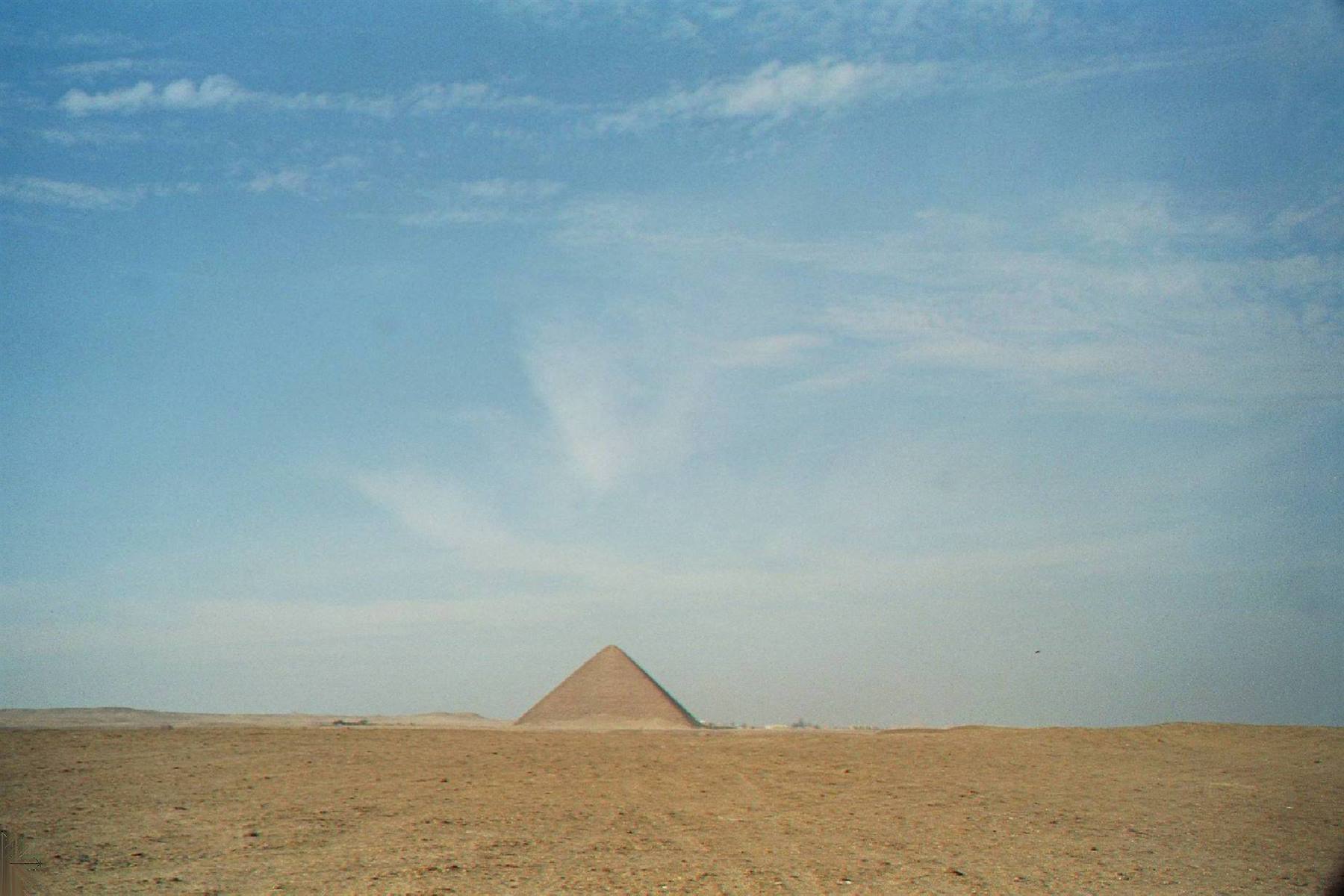 Great Pyramid of Giza rising above sandy desert under blue sky