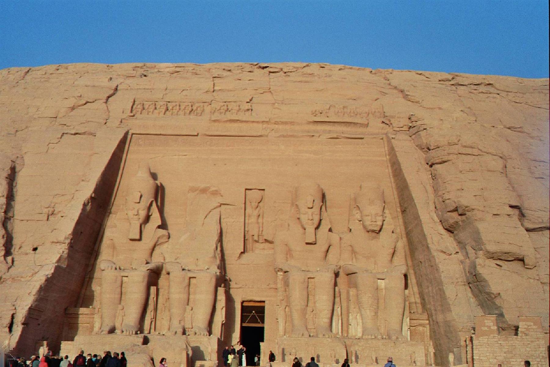 Tourists before the colossal statues of Ramses II carved into rock at Abu Simbel