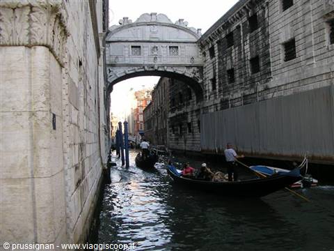 Gondolas passing under the Bridge of Sighs in Venice, daylight on canal