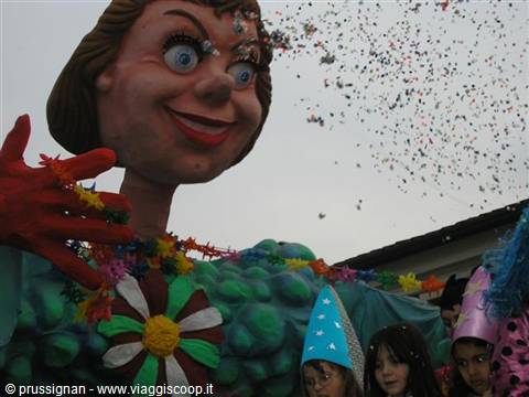 Carnival float with giant papier-mâché figure, falling confetti and children in pointed hats