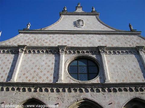 Diamond-patterned facade of San Francesco in Spina in Ferrara, round window, blue sky