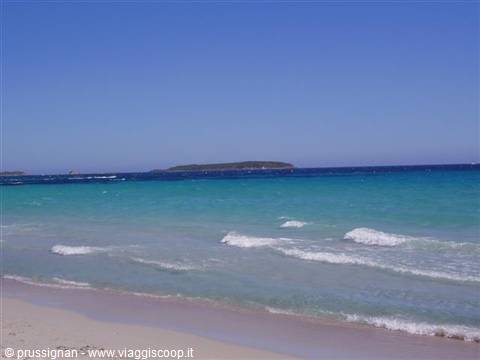 Turquoise waves on white sand, green island on the horizon under blue sky
