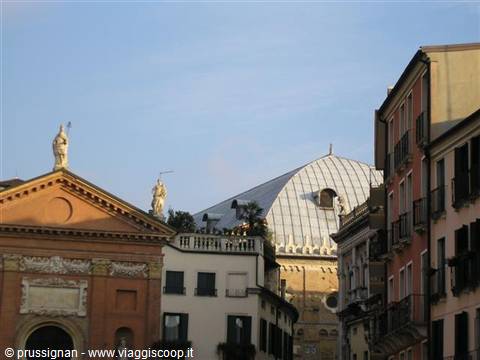 Statues and domed rooftops among old buildings in Padua, golden light