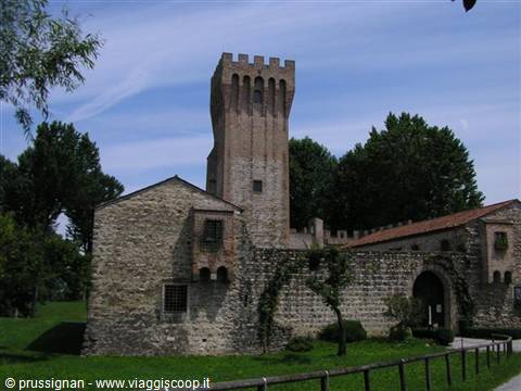 Stone castle with tall crenellated tower and walls under blue sky