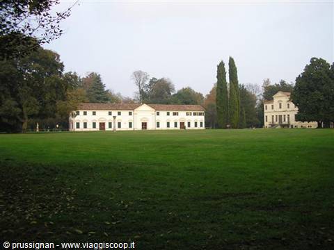 White Venetian villa with barchessa and wide lawn, grey sky