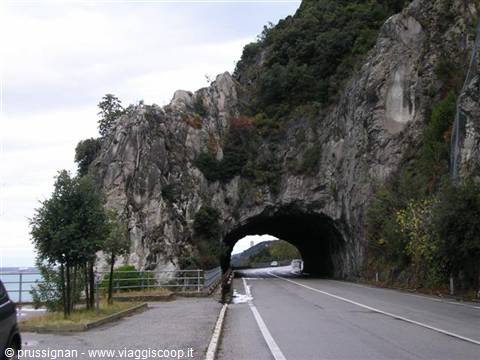 Coastal road entering a tunnel carved into the rock