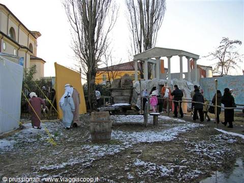 Costumed figures near an ancient-style temple, snow on the ground