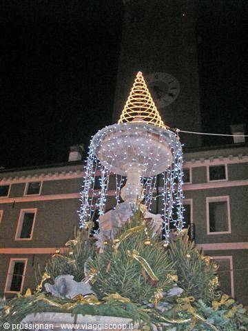 Fountain decorated for Christmas: blue lights and golden cone at night
