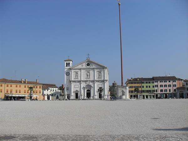 Palmanova's Piazza Grande: white cathedral with statues and tall flagpole