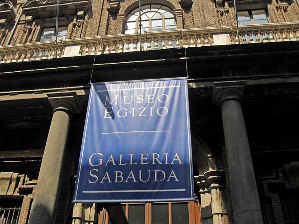 Blue banner of Museo Egizio and Galleria Sabauda on brick facade, daylight