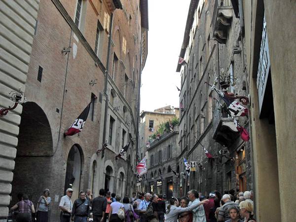 flags and crowd in the streets of Siena