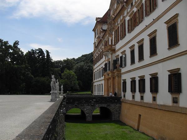 Eggenberg Palace: baroque facade, stone statues and arched stone bridge over the moat