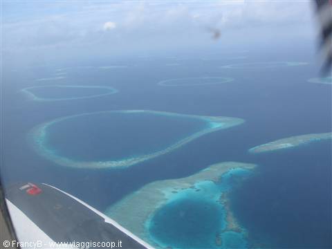Turquoise coral atolls seen from the seaplane over the Maldives ocean