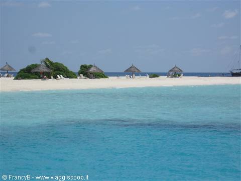 Thatched umbrellas on white sand beach with turquoise tropical sea