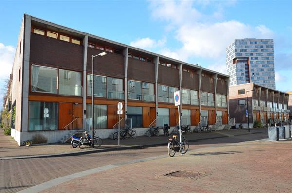Row of brick houses with parked bicycles under a blue sky