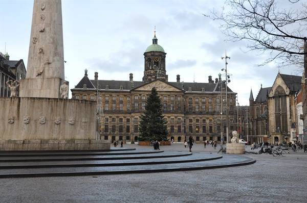 Christmas tree and passersby in front of the Royal Palace on Dam Square, Amsterdam