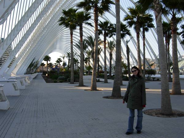 Woman among palm trees under the white structures of Ciutat de les Arts i les Ciències