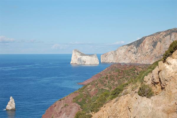 Limestone cliffs at Nebida, white sea stacks over deep blue water, Mediterranean shrubs