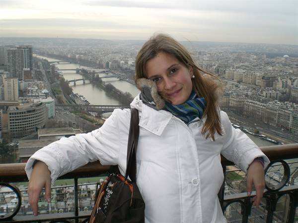 Woman in white coat on the Eiffel Tower terrace, the Seine and bridges