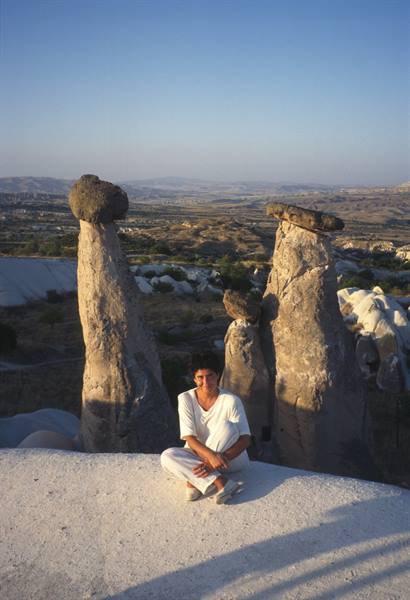 Woman sitting among Cappadocia fairy chimneys in golden light