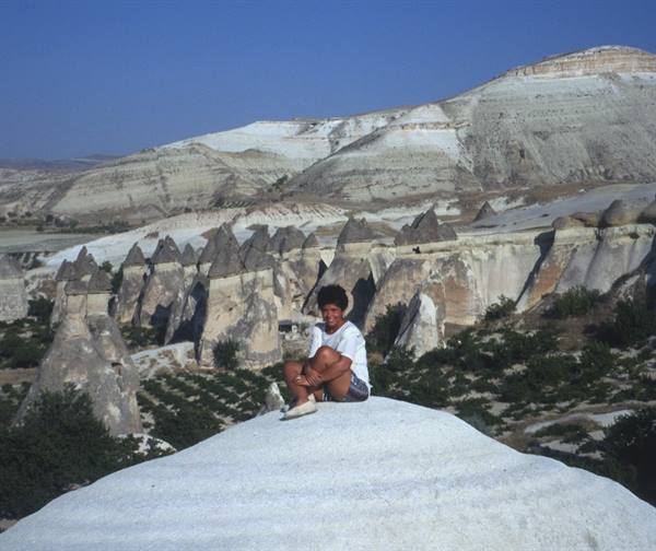 Boy sitting on a rock among the fairy chimneys of Cappadocia