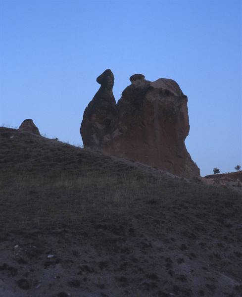 Rock fairy chimneys in Cappadocia at dusk above the bare slope