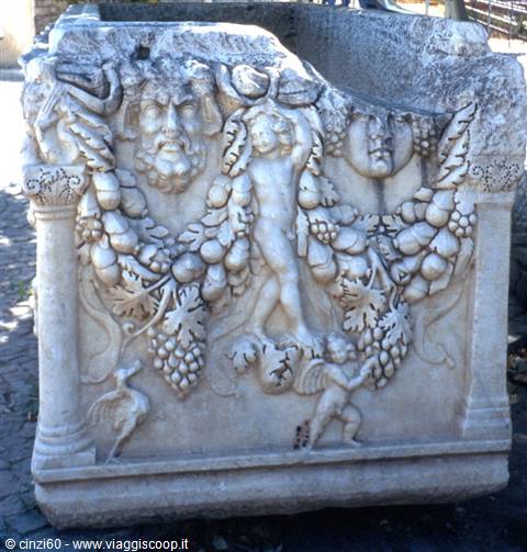 Marble sarcophagus carved with fruit garlands, putti and theatrical masks