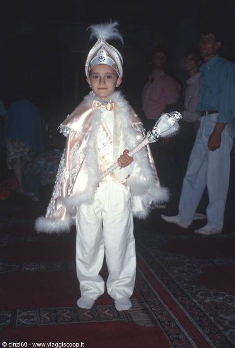 Boy in ceremonial costume with feather cape and scepter, Turkey