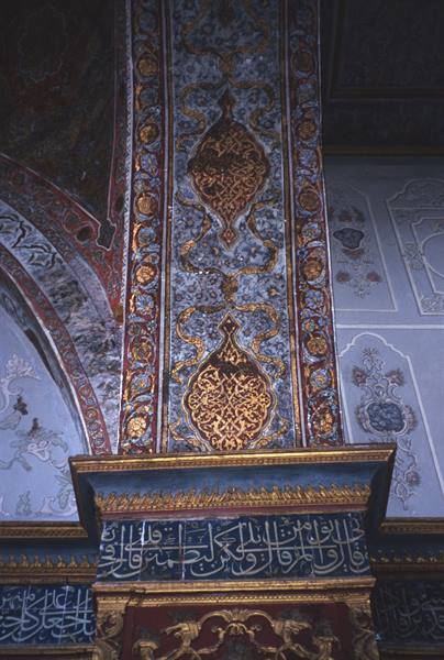Column decorated with golden arabesques and Ottoman calligraphy inside a mosque