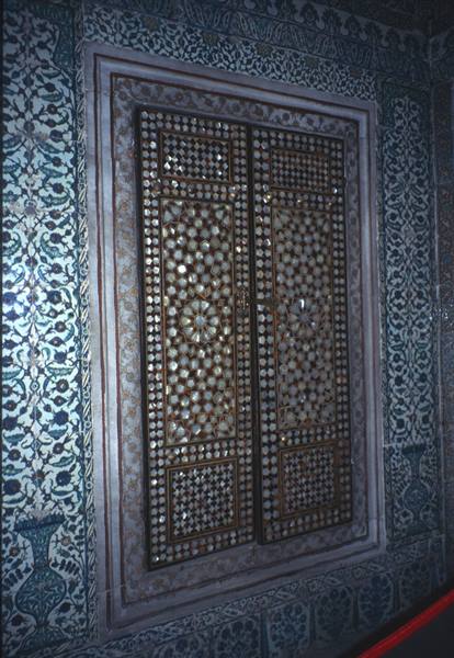 Mother-of-pearl inlaid wooden door framed by blue and white tiles