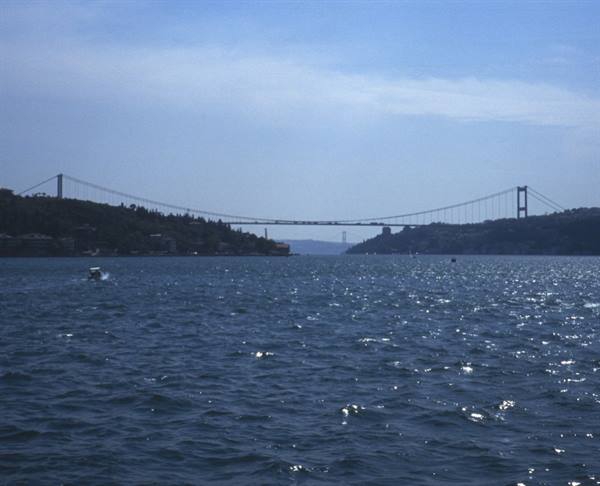 Suspension bridge over the Bosphorus, sparkling water and passing boat